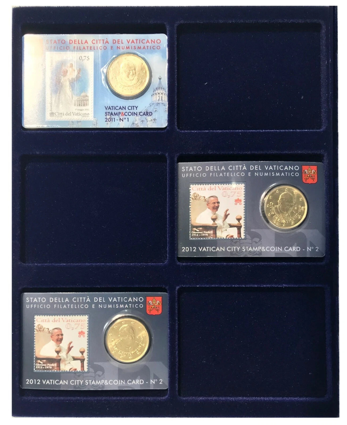 A dark blue velvet coin tray with six compartments, holding three Vatican City coin cards, each showing a vintage stamp and a gold coin. The cards are labeled 'Stato della Città del Vaticano' and 'Vatican City Stampcoin Card'.