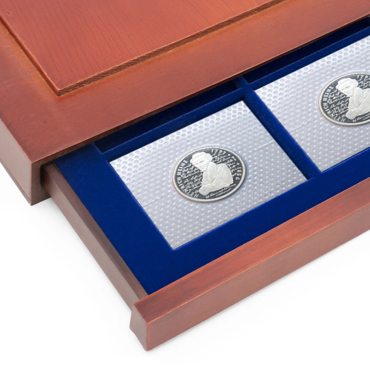 Detail shot of open wooden stackable drawer unit with a blue velvet tray for coin cards on a white background