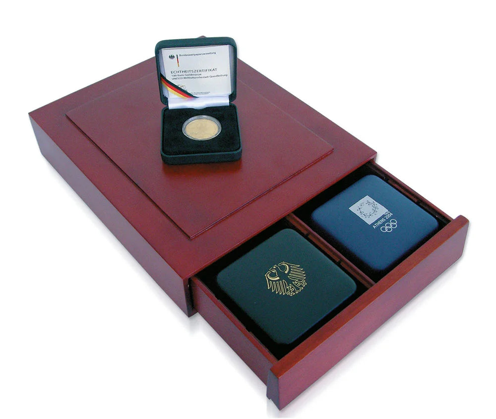 Open wooden stackable drawer with two green cases and a small open case containing a gold coin on a white background