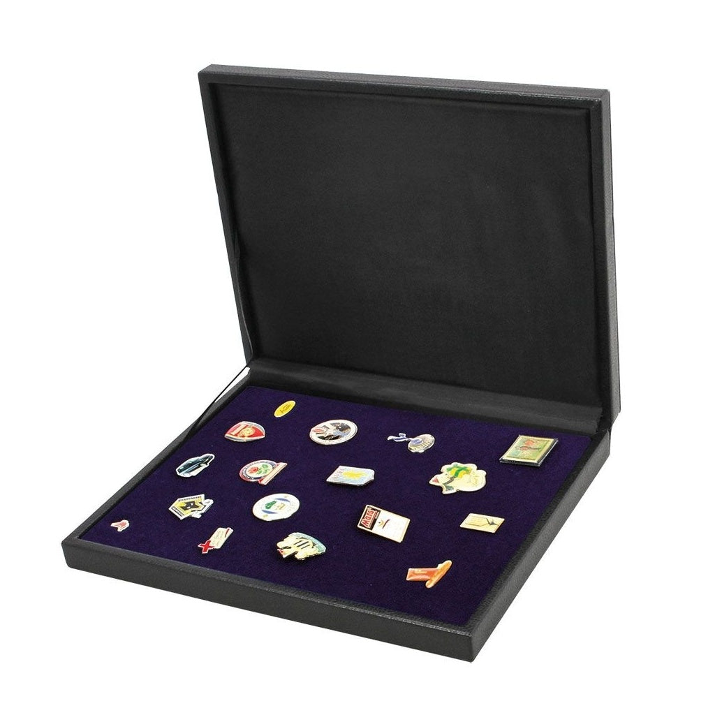 Collection of pins on a blue velvet tray in an open black leather display case, on a white background.