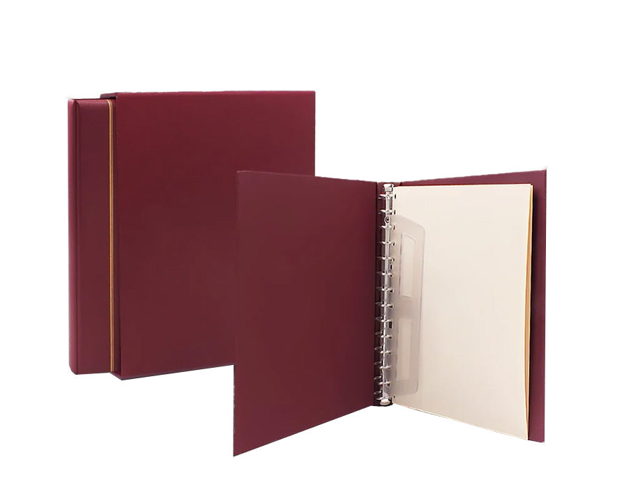 Wine red Morocco album with a gold embossed line, inserted into the wine red Morocco slipcase with an open wine red album revealing the 14-ring mechanism and sheet lifter. All on a white background.