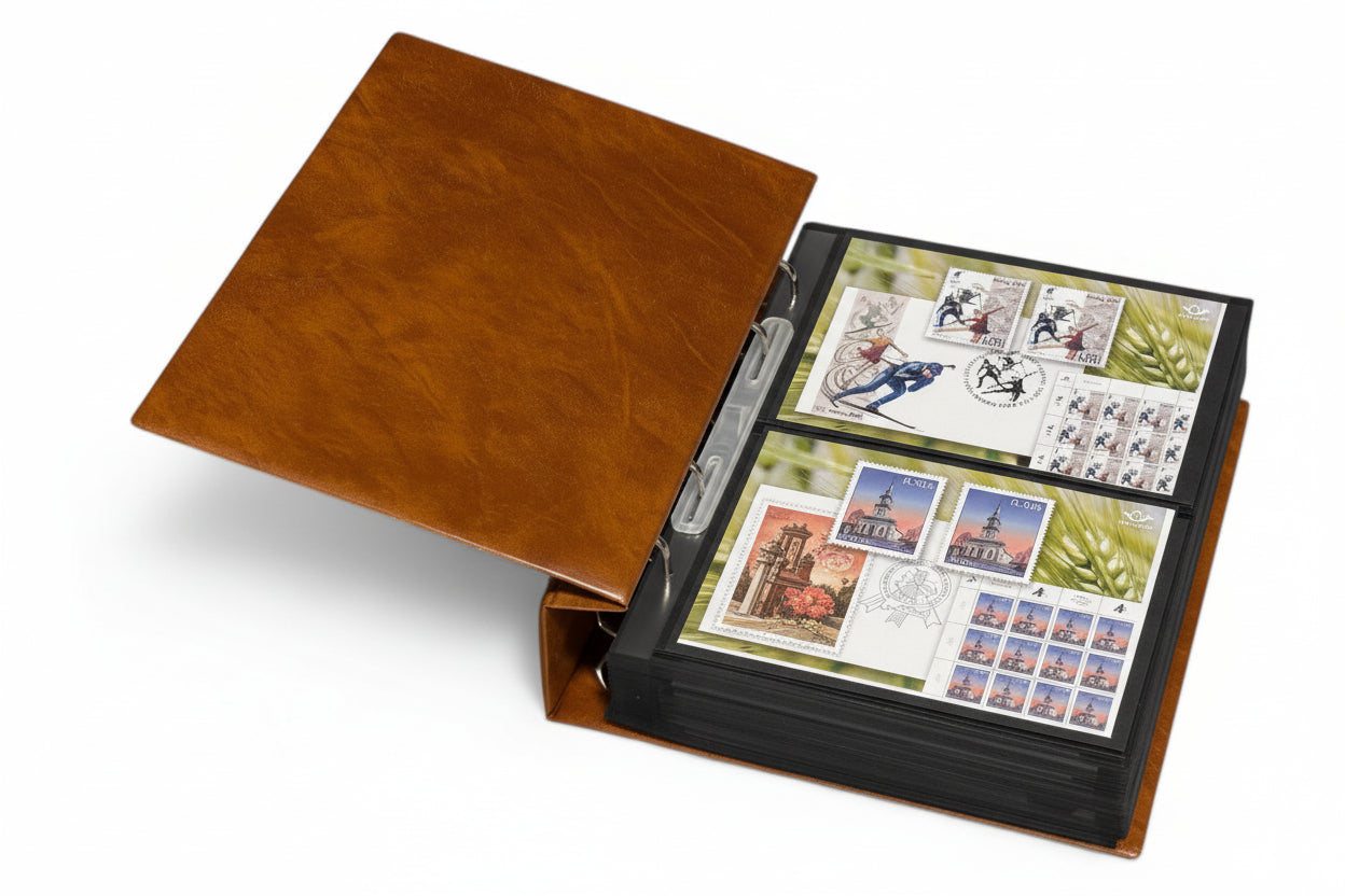 Tan stamp album laid open with black pages displaying stamps  & covers on a white background