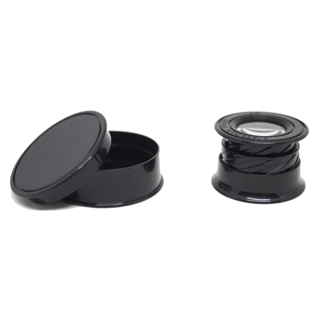 A twist to open circular magnifying lens, fully expanded, next to the black case on a white background