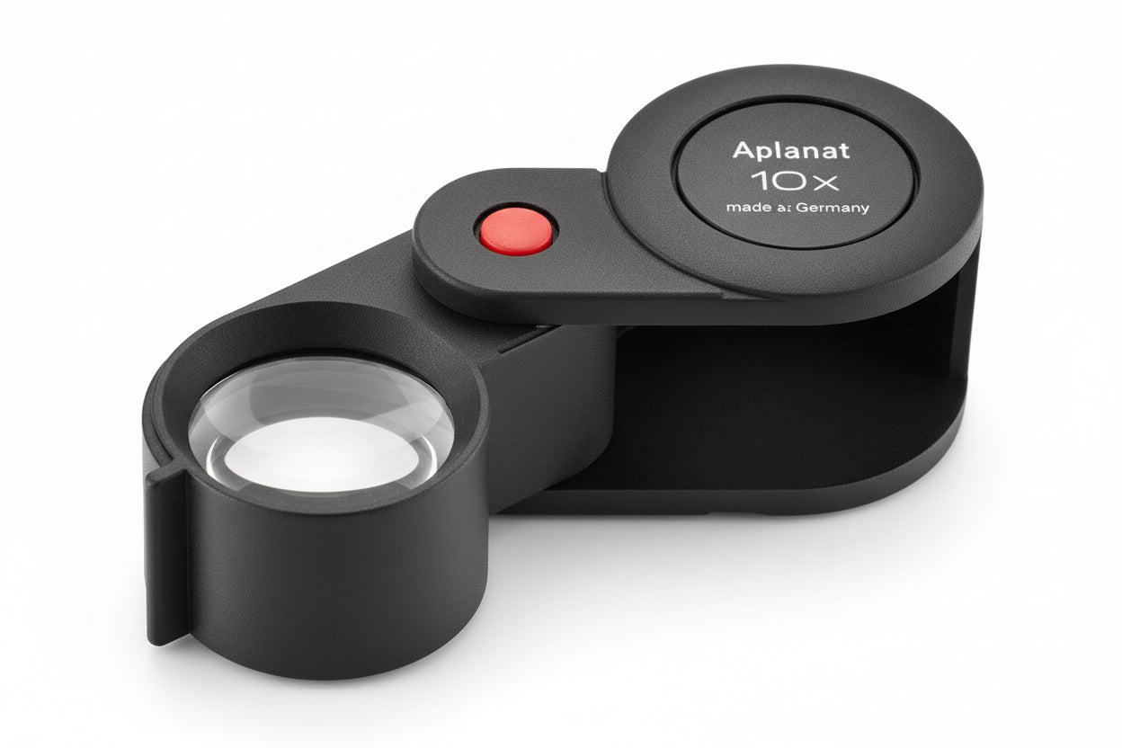 Black Aplanatic Folding Magnifying Glass Loupe with 10x magnification on a white background