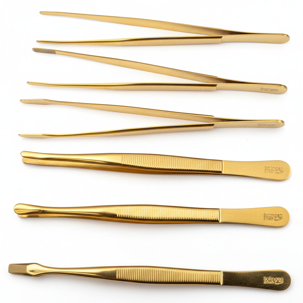 Set of 6 gold-colored stamp tongs (with different tips) on a white background